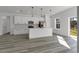 Modern white kitchen featuring stainless steel appliances, pendant lighting and a large island at 15657 Sw 37Th Cir, Ocala, FL 34473
