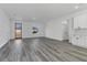 Bright, spacious living room featuring modern gray wood flooring, a large window and new cabinets at 15657 Sw 37Th Cir, Ocala, FL 34473