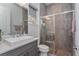Modern bathroom featuring a glass enclosed shower with decorative tiles, a square sink, and gray vanity at 15732 Shorebird Ln, Winter Garden, FL 34787