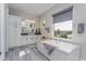 Luxurious bathroom featuring a soaking tub, a large window, and a double sink vanity at 15732 Shorebird Ln, Winter Garden, FL 34787