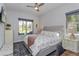 Bright bedroom with large windows, a ceiling fan, and a comfortable bed with decorative pillows at 15732 Shorebird Ln, Winter Garden, FL 34787