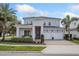 Beautiful two-story home with manicured landscaping, brick driveway, and white stone accents at 15732 Shorebird Ln, Winter Garden, FL 34787