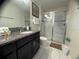 Clean bathroom with a glass-enclosed shower, granite vanity, and tile flooring at 1580 Tempo Ln, Davenport, FL 33896
