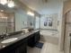 Well-appointed bathroom featuring double sinks, a soaking tub, and a separate glass shower at 1580 Tempo Ln, Davenport, FL 33896