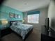 Bright bedroom featuring a queen-sized bed, matching lamps, and a calming teal accent wall at 1580 Tempo Ln, Davenport, FL 33896