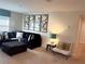 Bright living room with a comfortable black couch, colorful artwork and soft, neutral colored carpet at 1580 Tempo Ln, Davenport, FL 33896