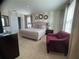 Cozy bedroom showcasing a comfortable king bed, accent chair, and neutral decor at 1580 Tempo Ln, Davenport, FL 33896