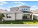 View of the rear exterior of the house with a brick patio, sliding glass doors, and a fenced-in backyard with green grass at 15863 Citrus Grove Loop, Winter Garden, FL 34787