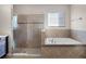 Bathroom with a glass shower, tub, and tile surround at 15863 Citrus Grove Loop, Winter Garden, FL 34787