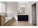 Bathroom with a large soaking tub, dark wood cabinetry, and tile flooring at 15863 Citrus Grove Loop, Winter Garden, FL 34787