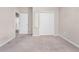 Neutral bedroom with carpet features closet with mirrored door and access to hallway at 15863 Citrus Grove Loop, Winter Garden, FL 34787