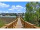 Picturesque view from a wooden dock extending over the lake, showcasing waterfront homes and a tranquil setting at 15863 Citrus Grove Loop, Winter Garden, FL 34787