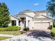 Attractive two-story home boasting a brick driveway, stone accents, and manicured landscaping at 15863 Citrus Grove Loop, Winter Garden, FL 34787