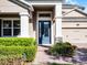 Close-up of the home's entrance showing the stylish blue front door and well-maintained landscaping at 15863 Citrus Grove Loop, Winter Garden, FL 34787