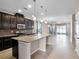 Bright kitchen featuring dark cabinetry, granite countertops, stainless steel appliances, and a spacious island with pendant lighting at 15863 Citrus Grove Loop, Winter Garden, FL 34787