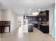 Spacious kitchen with dark cabinetry, granite countertops, stainless steel appliances, and a large island, flowing into the living area at 15863 Citrus Grove Loop, Winter Garden, FL 34787