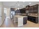 Well-lit kitchen showcasing dark wood cabinets, stainless steel appliances, granite countertops, and a large island with pendant lights at 15863 Citrus Grove Loop, Winter Garden, FL 34787