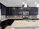 Beautiful kitchen with dark wood cabinetry, stainless steel appliances, granite countertops and backsplash, plus a central island at 15863 Citrus Grove Loop, Winter Garden, FL 34787