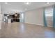 Open-concept living room shows tile flooring, natural light, and dark kitchen cabinetry at 15863 Citrus Grove Loop, Winter Garden, FL 34787