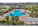 Aerial view of a uniquely shaped community pool surrounded by lounge chairs, palm trees, and a pergola at 15863 Citrus Grove Loop, Winter Garden, FL 34787