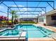 Screened-in pool area with a hot tub, a small waterfall, and elegant stone accents at 16033 Citrus Knoll Dr, Winter Garden, FL 34787