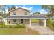Charming two-story home featuring a covered porch and carport, set in a lush green lawn at 1604 Roosevelt Ave, Orlando, FL 32804