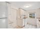Clean and well-lit kitchen with a window, white cabinets, and white appliances at 1604 Roosevelt Ave, Orlando, FL 32804