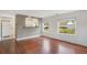 Bright room featuring hardwood floors, a kitchen view, and multiple windows providing natural light at 1604 Roosevelt Ave, Orlando, FL 32804