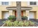 Close up exterior image of a tan building with garages and a large tree at 1616 Legacy Park Dr # 1616, Maitland, FL 32751