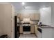 Well-lit kitchen featuring an electric range oven, a black refrigerator, and a stainless steel sink at 1616 Legacy Park Dr # 1616, Maitland, FL 32751