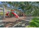 Community playground featuring slides, climbing structures and a soft landing surface, with shade trees nearby at 1616 Legacy Park Dr # 1616, Maitland, FL 32751