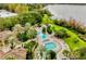 Beautiful aerial view of a resort-style pool, deck with lounge chairs, and lush landscaping with lake in the background at 1616 Legacy Park Dr # 1616, Maitland, FL 32751