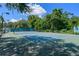 Well-maintained tennis court with professional-grade surface, surrounded by lush greenery and mature trees at 1616 Legacy Park Dr # 1616, Maitland, FL 32751