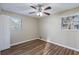 Bedroom with wood-look floors, two windows with blinds, and a ceiling fan with lights at 1707 Gammon Ln, Orlando, FL 32811