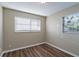 Bedroom with wood-look floors and natural light from the two windows with blinds at 1707 Gammon Ln, Orlando, FL 32811