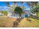 Side view of a cozy home with a covered porch, a well-kept yard, and mature trees at 1707 Gammon Ln, Orlando, FL 32811