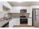 Modern kitchen featuring granite countertops, white cabinets, and stainless steel appliances at 1707 Gammon Ln, Orlando, FL 32811