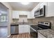 Well-designed kitchen with granite countertops, stainless steel appliances, and white cabinetry at 1707 Gammon Ln, Orlando, FL 32811