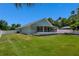 Landscaped backyard featuring a patio, screened lanai, green grass, and a fenced pool at 2243 Davis Dr, New Smyrna Beach, FL 32168