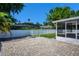 Landscaped backyard with a spacious brick patio, white fence, and a screened-in pool area at 2243 Davis Dr, New Smyrna Beach, FL 32168