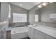 Bright bathroom featuring a bathtub with tiled walls and a vanity with plenty of cabinet storage space at 2243 Davis Dr, New Smyrna Beach, FL 32168