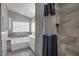 Bathroom featuring a tiled bathtub, vanity with storage space and an adjacent shower room at 2243 Davis Dr, New Smyrna Beach, FL 32168