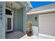 Inviting front entrance featuring a stylish door with decorative glass, lantern-style lighting, and fresh landscaping at 2243 Davis Dr, New Smyrna Beach, FL 32168