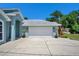 Exterior view of the home featuring a two-car garage, fresh landscaping, and modern exterior lighting at 2243 Davis Dr, New Smyrna Beach, FL 32168