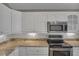 Updated kitchen with white cabinets, granite countertops, stainless steel microwave, and electric cooktop at 2243 Davis Dr, New Smyrna Beach, FL 32168