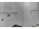 Bright laundry room with overhead cabinets and modern flooring at 2243 Davis Dr, New Smyrna Beach, FL 32168