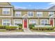 Charming townhome with red door, well-maintained landscaping, and a welcoming exterior at 2602 Lodi Cir # 105, Kissimmee, FL 34746