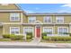 Charming townhome with red door, well-maintained landscaping, and a welcoming exterior at 2602 Lodi Cir # 105, Kissimmee, FL 34746