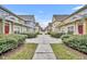 Picturesque street view of colorful townhouses lined with manicured shrubbery, creating a serene residential atmosphere at 2611 Gala N Rd # 105, Kissimmee, FL 34746