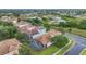 Aerial view of a home with a screened pool and tile roof, located near a pond at 2621 Archfeld Blvd, Kissimmee, FL 34747